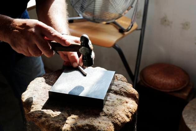 Jeweller hammering on metal to make jewelry in workshop model released, Symbolfoto property released, RFTF00313