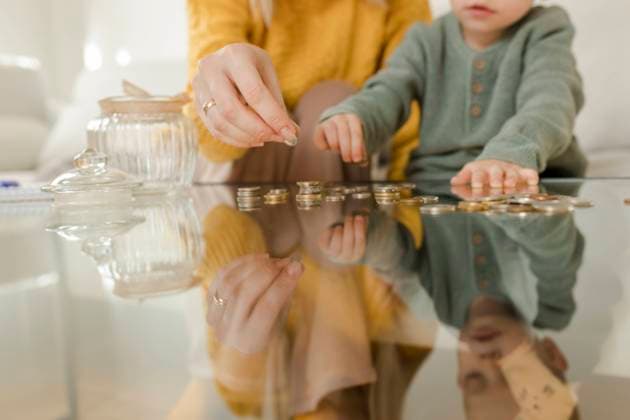 Young woman with son counting coins on table at home model released, Symbolfoto property released, VIVF00096
