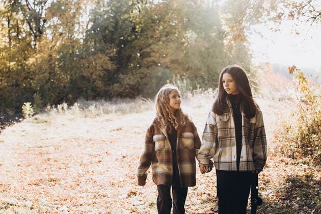 IMAGO Creative, Jahreszeit Herbst, Ferien Girl holding hands with sister and walking in forest on sunny day model released, Symbolfoto, YLF00024