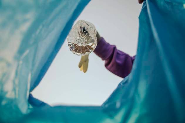 Volunteer putting plastic bottle in garbage bag model released, Symbolfoto, ACPF01536