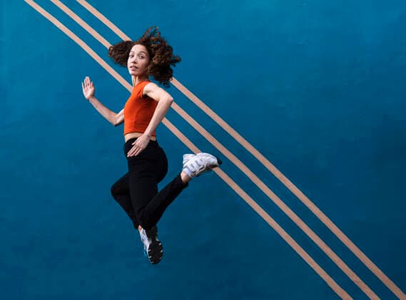 Creative Highlights Symbolbilder Woman jumping in front of blue wall model released, Symbolfoto, AMWF00990