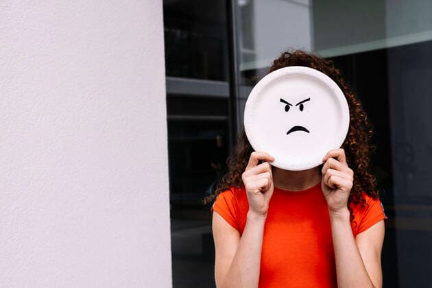 Creative Highlights Symbolbilder Young woman holding angry emoticon plate over face model released, Symbolfoto property released, AMWF01007