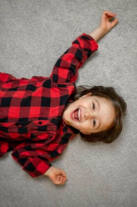 Creative Highlights Symbolbilder Cheerful boy wearing plaid shirt lying down on carpet model released, Symbolfoto property released, ANAF00507