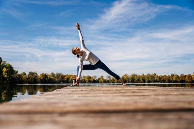 IMAGO Creative: Fit durch den Herbst Woman exercising on jetty under sky model released, Symbolfoto, DIGF19347