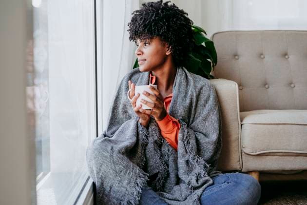 Young woman with coffee cup sitting by window at home model released, Symbolfoto property released, EBBF06919