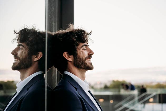 Creative Highlights Symbolbilder Happy businessman with eyes closed leaning on glass wall model released, Symbolfoto, EBBF07087