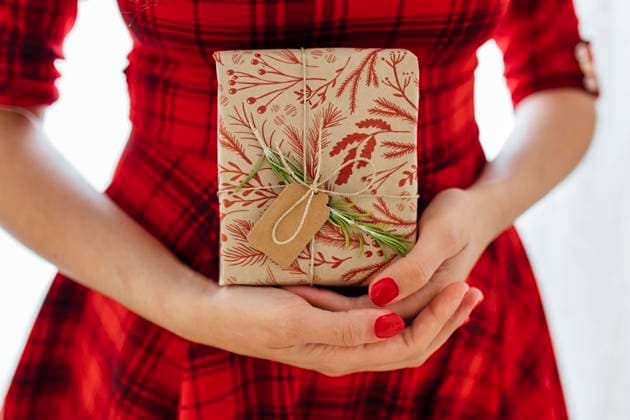 Creative Highlights Symbolbilder Woman in red dress holding Christmas gift model released, Symbolfoto, EGHF00632