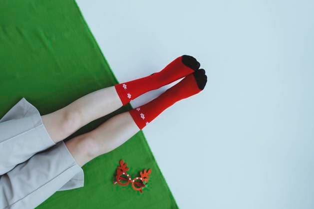 Creative Highlights Symbolbilder Girl sitting on floor wearing red Christmas socks by antler glasses model released, Symbolfoto, IEF00253