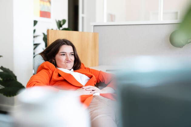 Creative Highlights Symbolbilder Businesswoman with puckering lips sitting on chair in office model released, Symbolfoto property released, JOSEF14642