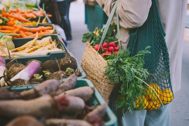 Woman holding shopping bags standing by vegetables in crate model released, Symbolfoto, NDEF00055