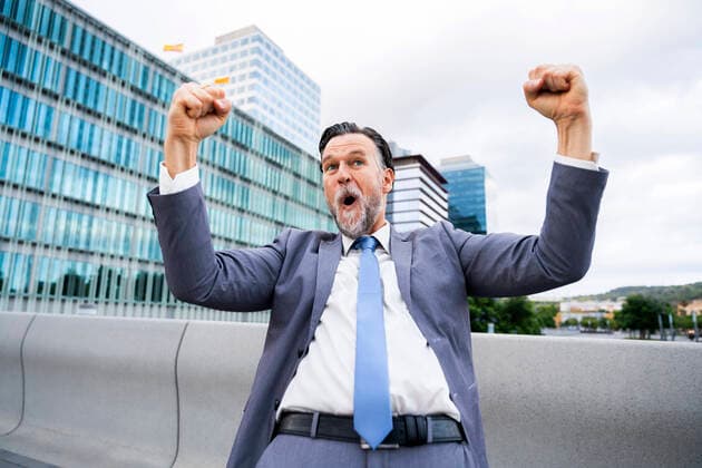 Creative Highlights Symbolbilder Excited mature businessman gesturing fists with arms raised outside building model released, Symbolfoto, OIPF02707