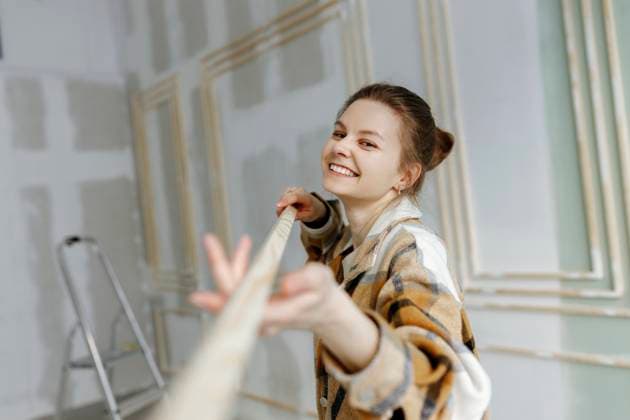 Creative Highlights Symbolbilder Smiling woman with wooden stick at home model released, Symbolfoto property released, VIVF00147