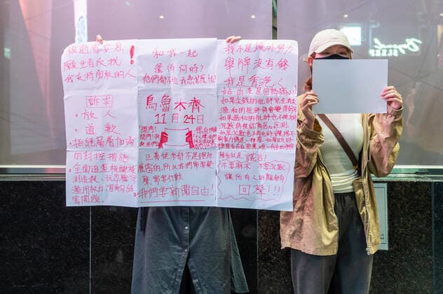 November 28, 2022, Hong Kong: A protester holds up a sign while another holds a blank piece of paper during a demonstration. Dozens gathered in solidarity with those in China rallying against the government s zero-COVID policies. Shortly after chanting do not want authoritarianism, do not want a monarchy, Wong was attacked by an assailant and knocked to the ground. Hong Kong - ZUMAs197 20221128_zaa_s197_130 Copyright: xBenxMaransx