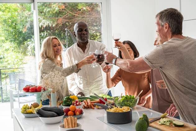 RECORD DATE NOT STATED Diverse group of senior friends making a toast while gathered around kitchen island Copyright: EricxAudras B84428746