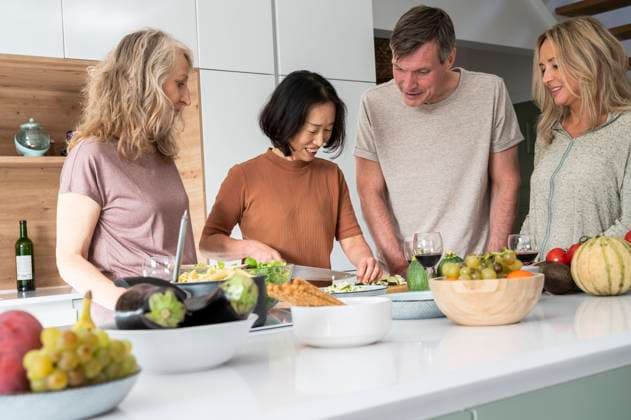 RECORD DATE NOT STATED Group of senior friends watching how to cook a meal while gathered around kitchen island Copyright: EricxAudras B91125946