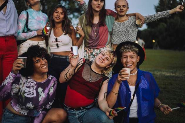 Portrait of happy friends enjoying together at park during sunset