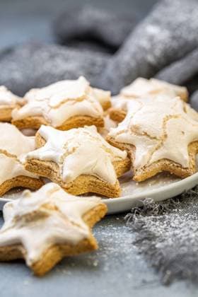 German Christmas almond cookies with cinnamon. Homemade German cinnamon cookies in the shape of a star in a plate on a gray concrete background, selective focus. Copyright: xZoonar.com MarinaxSaprunovax 13136949