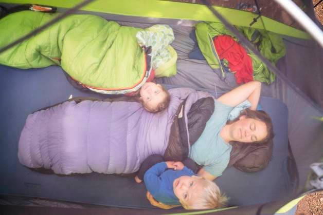 A mom and two young childen lie in their sleeping bags in a tent Maupin, Oregon, United States CR_AXTH22120116-1077437-01 ,model released, Symbolfoto