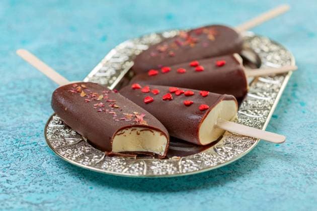 Homemade ice cream on a stick in dark chocolate icing. Homemade vanilla ice cream on a stick in dark chocolate glaze on a metal tray close up, selective focus. Copyright: xZoonar.com MarinaxSaprunovax 15907875