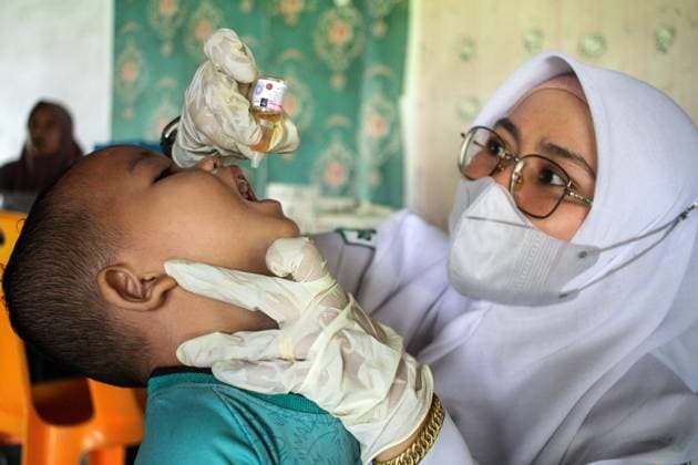 (221205) -- ACEH, Dec. 5, 2022 -- A health worker administers polio vaccine drops to a child during the National Immunization Week in Meunasah Langa village of Aceh Utara district, Aceh Province, Indonesia, Dec. 5, 2022. (Photo by Xinhua) INDONESIA-ACEH-POLIO-NATIONAL IMMUNIZATION WEEK FachrulxReza 
