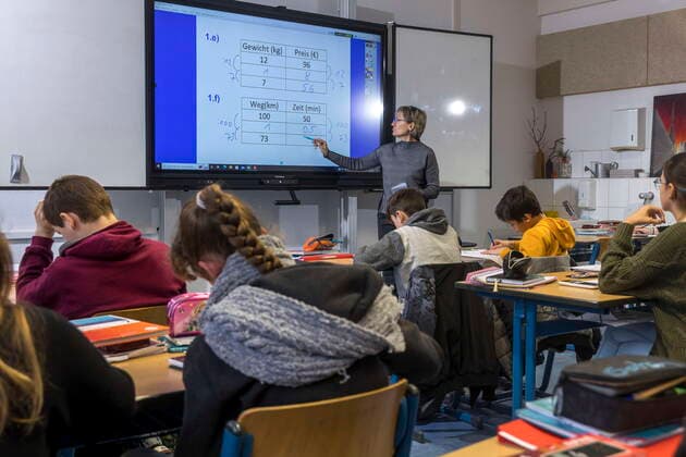 Schulunterricht mit einem interaktiven Whiteboard DEU Brandenburg Guben Â Europaschule Guben, interaktives Whiteboard satt Schultafel und Kreide: Silke Neugebauer unterrichtet in einer 7. Klasse Mathematik. In jedem Unterrichtsraum hängt eine der digitalen Schultafeln von demselben Hersteller mit der gleichen Software, so kommt der Einsatz der Digitaltechnik der Lebenswelt der Schüler sehr entgegen. An der Digitalisierung führt kein Weg vorbei, die Lehrer müssen ihre Unterrichtsplanung und -gestaltung völlig neu denken. 325 Schüler werden an der Oberschule in Guben von 31 Lehrern unterrichtet, ein Drittel davon sind Quereinsteiger. Eine Studie des mmb-Instituts der FDP-nahen Friedrich-Neumann-Stiftung zufolge brauchen die Schulen