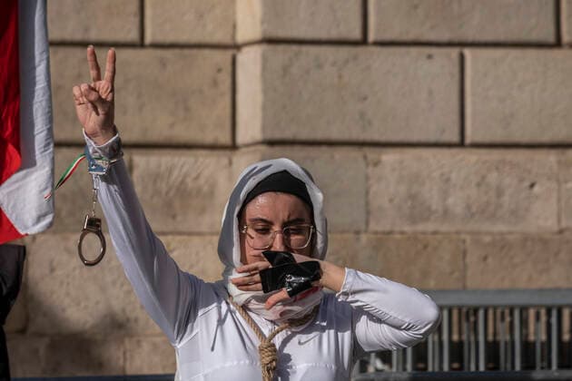December 10, 2022, Barcelona, Catalonia, Spain: A woman is seen enacting the repression of the Iranian regime with handcuffs and her mouth covered during the demonstration. Coinciding with Human Rights Day, hundreds of demonstrators have demonstrated in the center of Barcelona to protest against the repression of the Iranian regime and against the death sentences of those detained during the demonstrations. Barcelona Spain - ZUMAs197 20221210_zaa_s197_143 Copyright: xPacoxFreirex