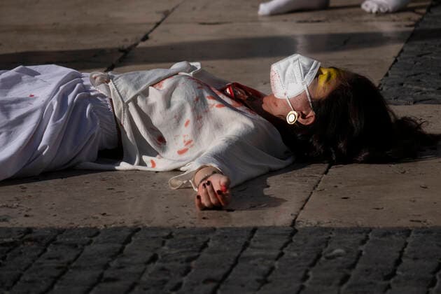 December 10, 2022, Barcelona, Catalonia, Spain: A woman stretched out on the ground of the Plaza de Sant Jaume covered in fake blood representing the repression of the Iranian regime seen during the demonstration. Coinciding with Human Rights Day, hundreds of demonstrators have demonstrated in the center of Barcelona to protest against the repression of the Iranian regime and against the death sentences of those detained during the demonstrations. Barcelona Spain - ZUMAs197 20221210_zaa_s197_148 Copyright: xPacoxFreirex