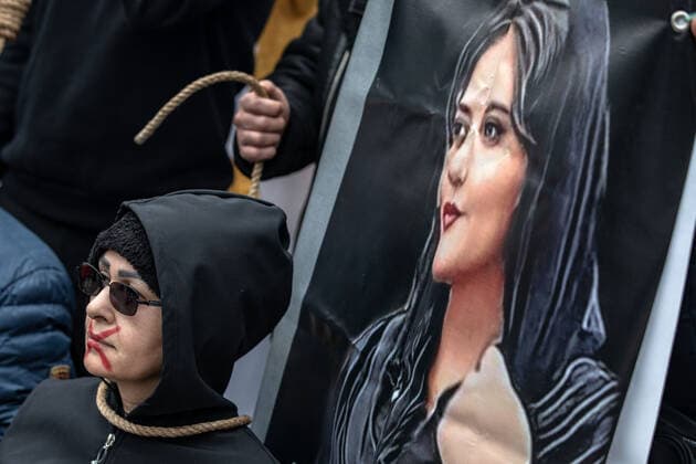 December 10, 2022, Istanbul, Turkey: A protester seen standing in front of the Mahsa Amini s painting during the demonstration. Mahsa Amini s death has sparked weeks of violent protests across Iran and other countries. Mahsa fell into a coma and died after being arrested in Tehran by the morality police for allegedly violating the country s hijab rules. In the trials regarding the protests, 11 people have been sentenced to death so far. Istanbul Turkey - ZUMAs197 20221210_zaa_s197_174 Copyright: xOnurxDogmanx