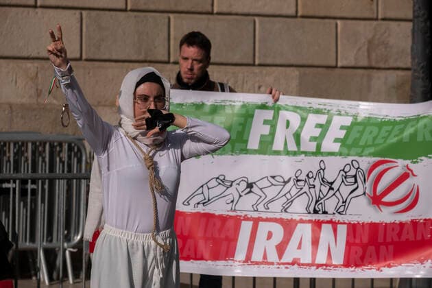 December 10, 2022, Barcelona, Catalonia, Spain: A woman is seen enacting the repression of the Iranian regime with handcuffs and her mouth covered during the demonstration. Coinciding with Human Rights Day, hundreds of demonstrators have demonstrated in the center of Barcelona to protest against the repression of the Iranian regime and against the death sentences of those detained during the demonstrations. Barcelona Spain - ZUMAs197 20221210_zaa_s197_144 Copyright: xPacoxFreirex