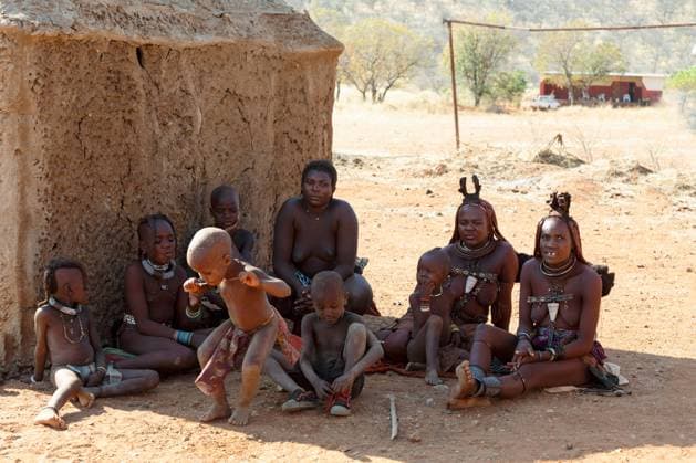 IMAGO Cultures of the world, Himba Volk in Namibia RECORD DATE NOT STATED NAMIBIA, KAMANJAB, OCTOBER 10: Himba tribe woman with child, in the village of Himba people near Kamanjab in northern Namibia, October 10, 2014, Namibia , 23400872.jpg, himba, northern, woman, culture, african, person, face, skin, tradition, tribal, native, authentic, beautiful, expression, necklace, hut, portrait, cultural, original, cute, head, bracelet, braid, smiling, front, nude, living, indigenous, africa, clay, ethnic, female, girl, hair, local, may, mud, namibia, natural, nature, near, outdoor, people, south, style, traditional, tribe, village, women, young,