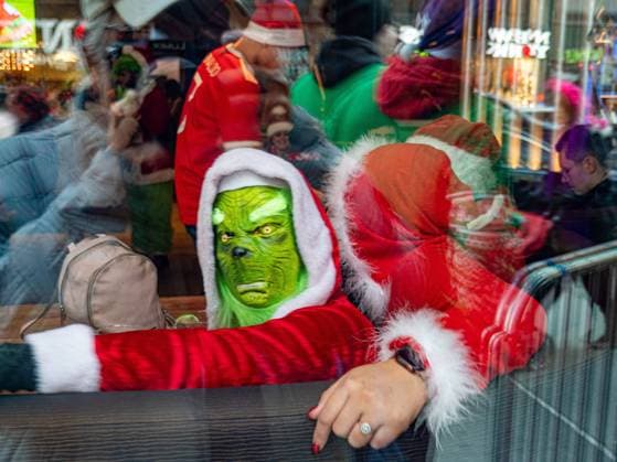 December 11, 2022, New York, New York, us: SantaCon 2022 returned to NYC with its annual barcrawl for charity. Hundreds of festive santas, elves, and other holiday revellers paraded in the Times Square neighborhood and waited on long lines at bars and restaurants for Christmas liquid cheer. The Grinch as seen through a bar window in Times Square. New York us - ZUMAh156 20221211_znp_h156_012 Copyright: xMiloxHessx