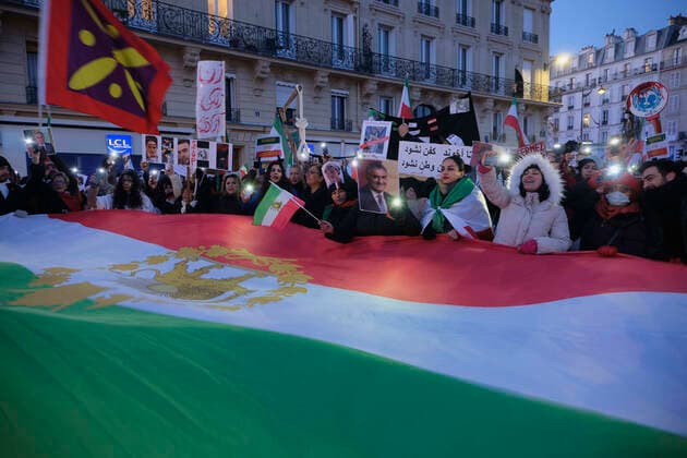 December 11, 2022, Paris, Ile de France, FRANCE: People hold the Iranian flag during a march in Paris to denounce the Islamic regime in Iran. Mohsen Shekari was the first Iranian to be excecuted on Thursday, december 8th 2022 by the increasingly repressive Iranian regime for participating in protests with more facing the death penalty on similar charges. Paris FRANCE - ZUMAh172 20221211_zip_h172_006 Copyright: xRemonxHaazenx