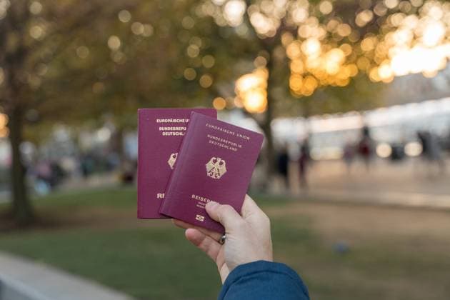 9 December 2022: A man holds two German passports in his hand. Passport *** Ein Mann hält zwei deutsche Reisepässe in der Hand. Reisepass