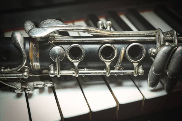 Detail einer antiken Klarinette, die am Klavier lehnt
