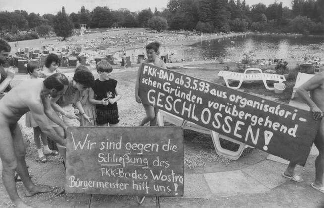 Sachsen, historisch, Urlaub, Ferien, Freizeit, Erholung, Naherholung: Dresden, Freibad Wostra FKK, Protest Unterschriftensammlung gegen drohende Schließung, Badegäste teilweise nackt (Achtung: Persönlichkeitsrechte ggf. zu klären), Plakate Transparente gegen die Schließung - Bürgermeister hilf uns! . 02.05.1993. Veröffentlichung in Sächsische Zeitung am 03.05.1993: Wostra-Bad wird dichtgemacht, weil der Pachtvertrag fehlt. Ab heute kein FKK mehr - Langwieriger Streit zwischen Stadt und Erbengemeinschaft. Vor verschlossenen Türen werden heute Sonnenhungrige im Strandbad Wostra stehen. Mit einem Schild macht das Sportamt die lieben Badegäste darauf aufmerksam, dass die Stadt dem Wunsch der Eigentümer nachkommt und den Betrieb einste Copyright: xSZ KlausxThierex 0000010103172916