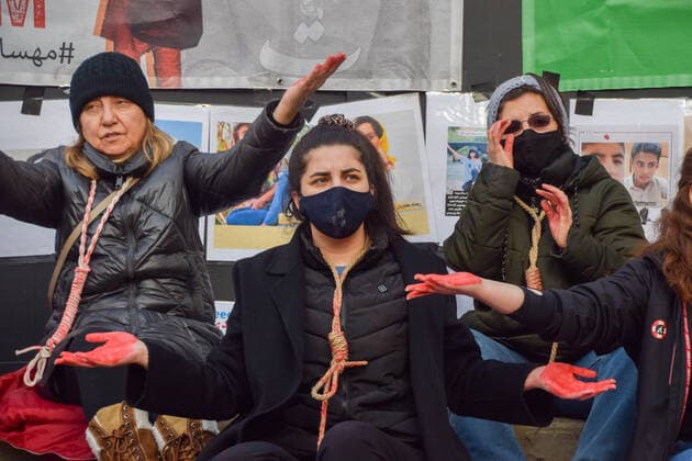 December 17, 2022, London, England, United Kingdom: A group of women staged a demonstration and performance in Piccadilly Circus in protest against the reported executions of anti-government protesters in Iran. The activists tied ropes around their necks and covered their hands in fake blood. London United Kingdom - ZUMAv130 20221217_zip_v130_017 Copyright: xVukxValcicx