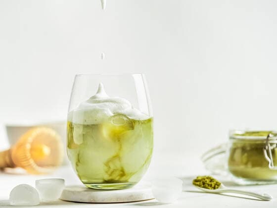 Iced Matcha Latte Tea with whipped cream Iced Matcha Latte Tea with whipped cream in tumbler glass and ingredients on white marble background. Copy space for txt or design Copyright: xZoonar.com OlgaxSergeevax 15372510