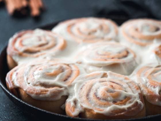 Vegan cinnamon rolls with topping close up Idea and recipe pastries - perfect cinnamon rolls with topping in skillet. Close up view of vegan swedish cinnamon buns Kanelbullar with pumpkin spice,topping vegan cream cheese. Copy space for text Copyright: xZoonar.com OlgaxSergeevax 15963706