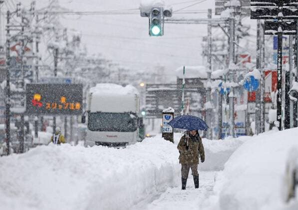 News Themen der Woche KW51 News Bilder des Tages Heavy snow in Niigata A woman walks on a street in Uonuma in Niigata Prefecture, Japan, on Dec. 20, 2022, following heavy snow.  1020663280st