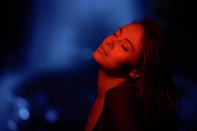 Creative Highlights Symbolbilder Young woman with closed eyes tilting head back under red neon light against blurred background at night, Model released Zhenikeyev_ID10632_321821_002 Copyright: xZhenikeyevx MR