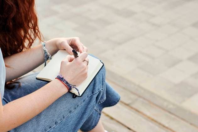 IMAGO Creative, Lifestyle, Tik Tok-Trend thatgirl Close-up of a young redhead woman writing in a notebook outdoors Alicante, Valencian Community, Spain CR_CRBL210706-782375-01 ,model released, Symbolfoto