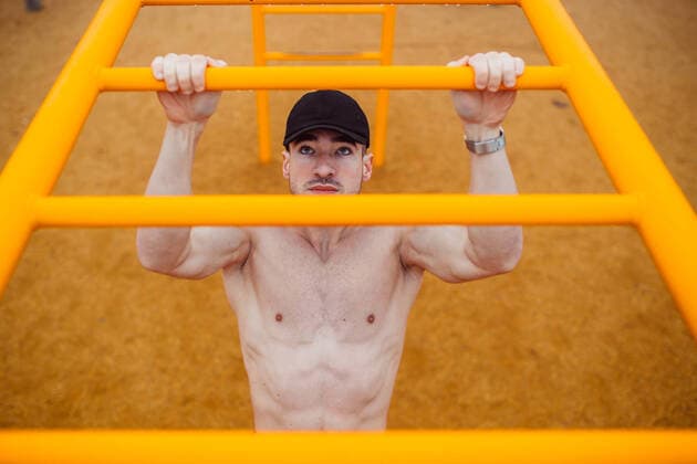 Creative Highlights Symbolbilder man with cap doing pull-ups in a calisthenics park. high angle Almería, AL, Spain CR_QYWX200623-433534-01 ,model released, Symbolfoto