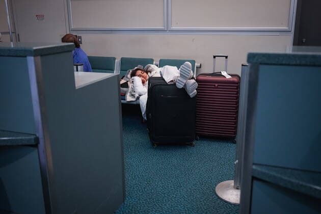 December 20, 2022, RICHMOND, BC, CANADA: A woman sleeps behind an airline counter at Vancouver International Airport after a snowstorm crippled operations leading to cancellations and major delays, in Richmond, B.C., on Tuesday, December 20, 2022. RICHMOND CANADA  - ZUMAc35_ 20221220_zaf_c35_063 Copyright: xDarrylxDyckx