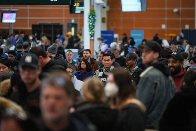 December 20, 2022, RICHMOND, BC, CANADA: RCMP officers walk through the crowd at Vancouver International Airport after a snowstorm crippled operations leading to cancellations and major delays, in Richmond, B.C., on Tuesday, December 20, 2022. RICHMOND CANADA  - ZUMAc35_ 20221220_zaf_c35_070 Copyright: xDarrylxDyckx