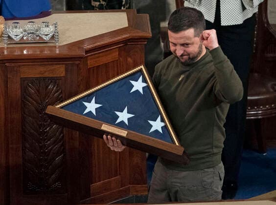 December 21, 2022, Washington, District of Columbia, USA: President Volodymyr Zelenskyy of Ukraine pumps his fist while holding a USA flag presented to him by Speaker of the United States House of Representatives Nancy Pelosi (Democrat of California), left, after he addressed a joint session of the US Congress in the US House Chamber of the US Capitol in Washington, DC on Wednesday, December 21, 2022 Washington USA - ZUMAs152 20221221_zaa_s152_181 Copyright: xCliffxOwenx