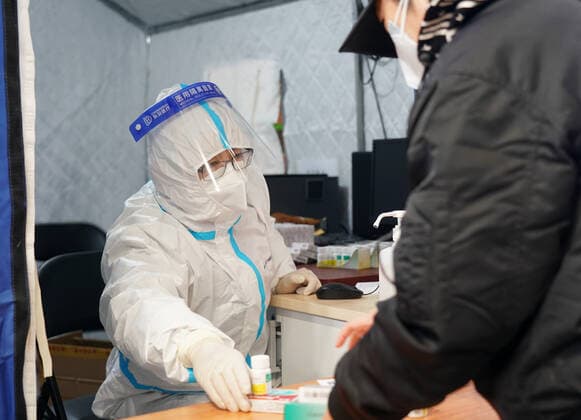 Coronavirus in China, provisorische Notunterkunft für Patienten mit Fieber in Peking (221224) -- BEIJING, Dec. 24, 2022 -- A medical worker passes medicine to a citizen in a makeshift fever clinic in Guang an Gymnasium in Beijing, capital of China, Dec. 24, 2022. In order to facilitate fever patients to seek medical treatment and ensure residents medical needs, some hospitals in Beijing set up makeshift fever clinics in gymnasiums to provide services such as diagnosis, prescription issuing and medicine dispensing for citizens. ) CHINA-BEIJING-GYMNASIUM-FEVER CLINIC (CN) ZhangxChenlin 