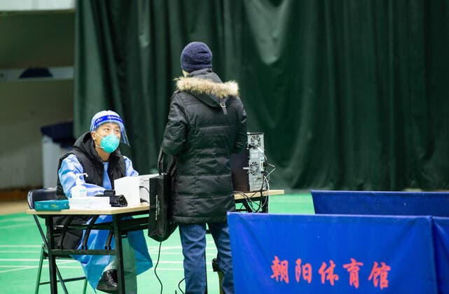 Coronavirus in China, provisorische Notunterkunft für Patienten mit Fieber in Peking (221224) -- BEIJING, Dec. 24, 2022 -- A medical worker gives medical advice to a citizen in a makeshift fever clinic of Beijing Chaoyang Hospital in Chaoyang Gymnasium in Beijing, capital of China, Dec. 24, 2022. In order to facilitate fever patients to seek medical treatment and ensure residents medical needs, some hospitals in Beijing set up makeshift fever clinics in gymnasiums to provide services such as diagnosis, prescription issuing and medicine dispensing for citizens. ) CHINA-BEIJING-GYMNASIUM-FEVER CLINIC (CN) ChenxZhonghao 