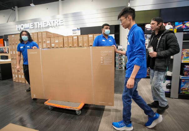 Kanada, Boxing Day in Vancouver (221226) -- VANCOUVER, Dec. 26, 2022 -- Employees of an electronics store help a customer transport a TV set during the Boxing Day sale in Vancouver, British Columbia, Canada, on Dec. 26, 2022. Boxing Day is one of the biggest shopping days in Canada. (Photo by Xinhua) CANADA-VANCOUVER-BOXING DAY SALE LiangxSen 