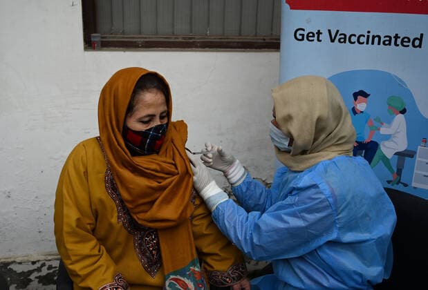 SRINAGAR, INDIA - DECEMBER 27: A woman receives a shot of booster dose of COVID19 vaccine on December 27, 2022 in Srinagar, India. Reports of a massive surge in Covid-19 infections in China and apprehensions over the possibility of a spill-over effect in India has led to a sharp uptick in the vaccination intake in the country. In the past week on Friday (December 23) and Saturday, more than one lakh vaccinations were administered in India against an average of between 40,000 and 50,000 doses through most of this month.(Photo By Waseem Andrabi Hindustan Times) Amid China Scare, Covid Booster Vaccination Picks Up In India