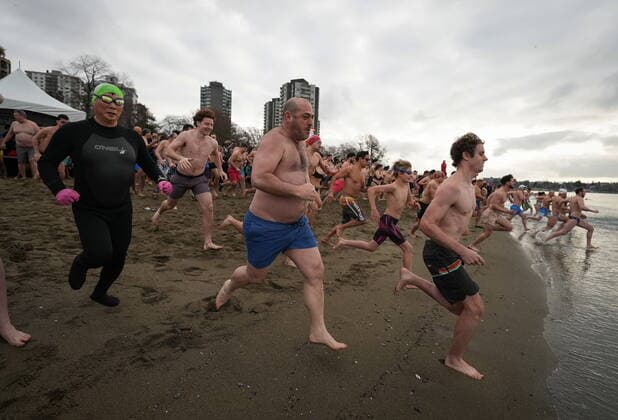 January 1, 2023, VANCOUVER, BC, CANADA: People sprint from the beach into English Bay during the Polar Bear Swim, in Vancouver, B.C., Sunday, Jan. 1, 2023. This year s event was the first since 2020 after the past two years were cancelled due to the COVID-19 pandemic. According to the City of Vancouver the initial swim was in 1920 when approximately 10 swimmers participated. VANCOUVER CANADA  - ZUMAc35_ 20230101_zaf_c35_045 Copyright: xDarrylxDyckx
